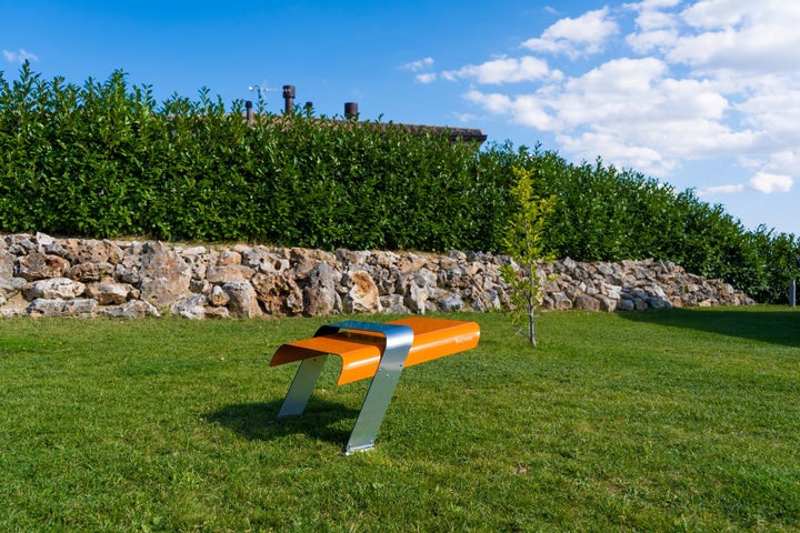 Outdoor Sitzbank aus Metall im Garten aufgestellt.