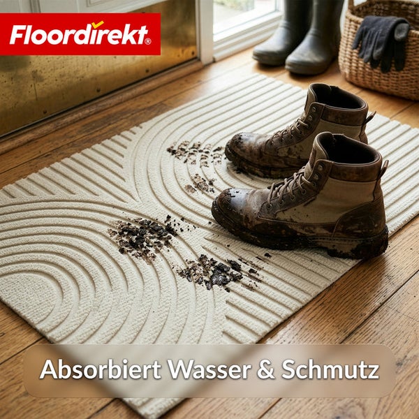 Strukturierte Schmutzfangmatte mit Wellenmuster im Eingangsbereich mit schlammigen Stiefeln auf Holzboden. Floordirekt Logo.