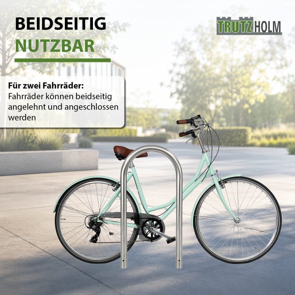 Ein beidseitig nutzbarer Trutzholm Fahrradständer aus Edelstahl in U-Form mit einem Fahrrad im Außenbereich.
