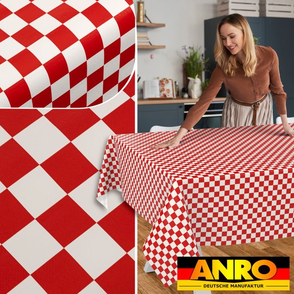 Frau breitet eine abwaschbare Wachstuchtischdecke mit rot-weißem Karomuster auf einem Tisch in einer Küche aus, ANRO Deutsche Manufaktur Logo.