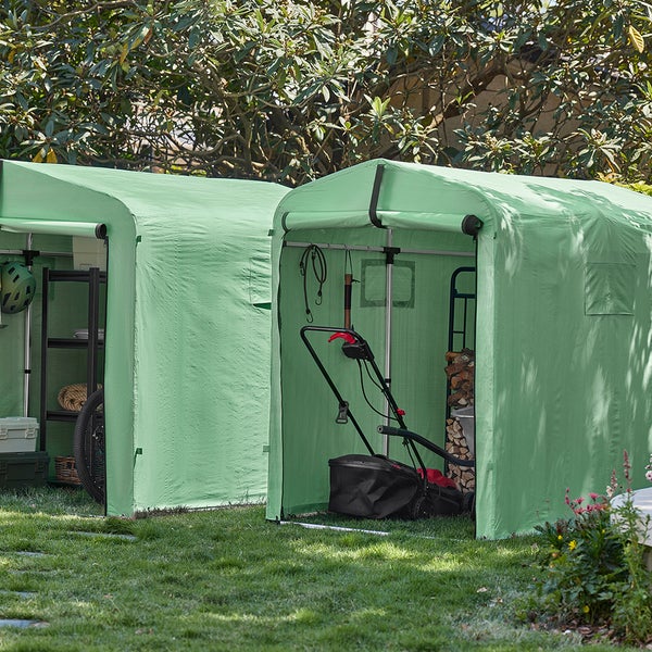 Zwei grüne Gerätezelte im Garten mit Gartengeräten