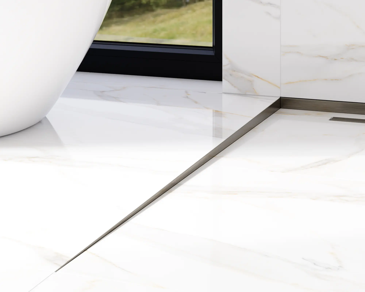 Metallprofilleiste integriert in einen marmorierten Fliesenboden in einem hellen, modernen Badezimmer neben einer Badewanne.