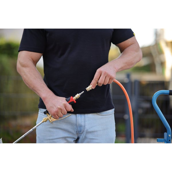 Eine Person verbindet eine Sprühlanze mit einem Gartenschlauch.