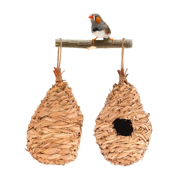 Drei hängende Vogelhäuser aus Stroh mit einem Vogel, der gefüttert wird