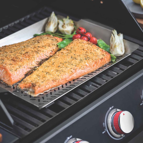 Zwei Lachsfilets mit Gemüse auf einer Grillplatte auf einem Grill