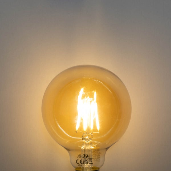 Leuchtende LED-Filament-Globelampe mit sichtbaren warmen Leuchtfäden und klarem Glas.