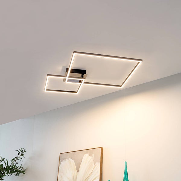 Moderne LED-Deckenleuchte mit zwei ineinandergreifenden quadratischen Rahmen an einer Decke in einem hellen Raum mit Dekoration.