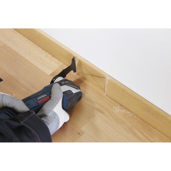 Oszillierendes Elektrowerkzeug beim Schneiden einer Holzfußleiste