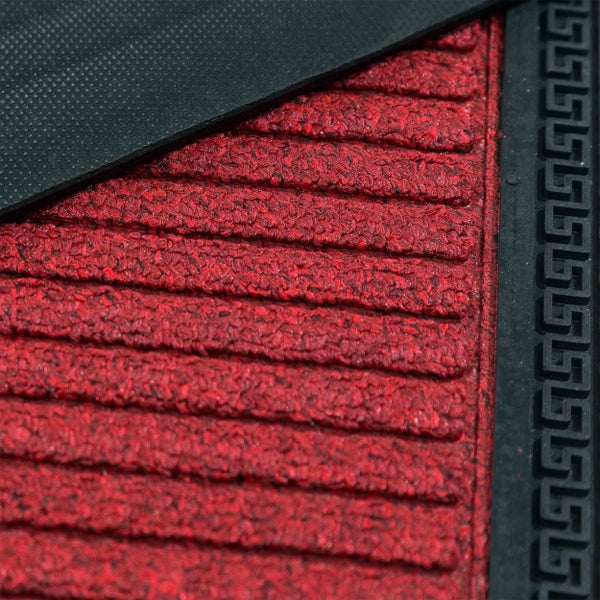 Detailaufnahme einer roten Fußmatte mit Rillenprofil und einem Bordürenmuster