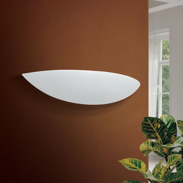 Moderne halbrunde Wandleuchte aus Gips in blattartiger Form an einer braunen Innenwand mit Zimmerpflanze.