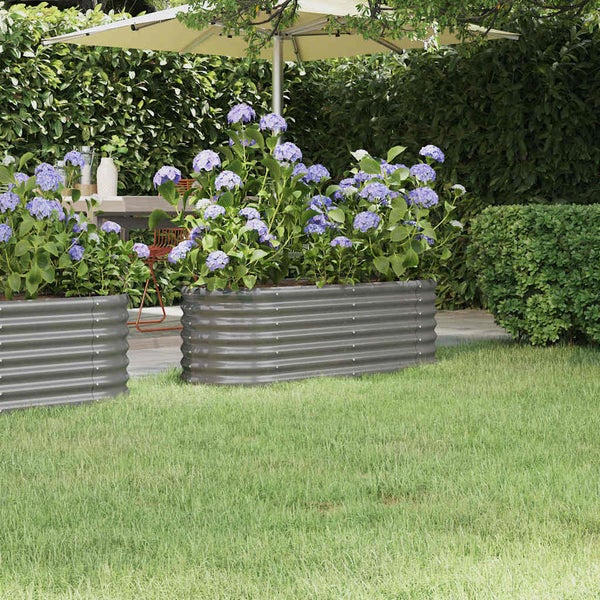 Ovales Hochbeet aus Wellblech, bepflanzt mit Hortensien in einem Garten mit Terrasse und Rasen.