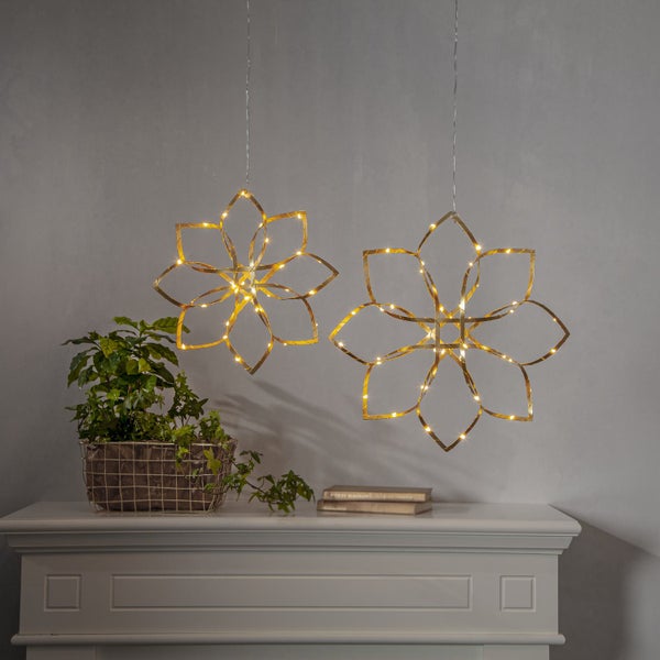 Zwei goldene LED-Blumenhängeleuchten über einem Kaminsims mit Topfpflanze.