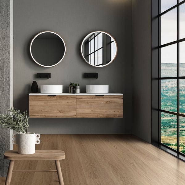 Modernes Badezimmer mit zwei runden LED Spiegeln und einem Doppelwaschtisch aus Holz vor einem großen Fenster mit Aussicht.