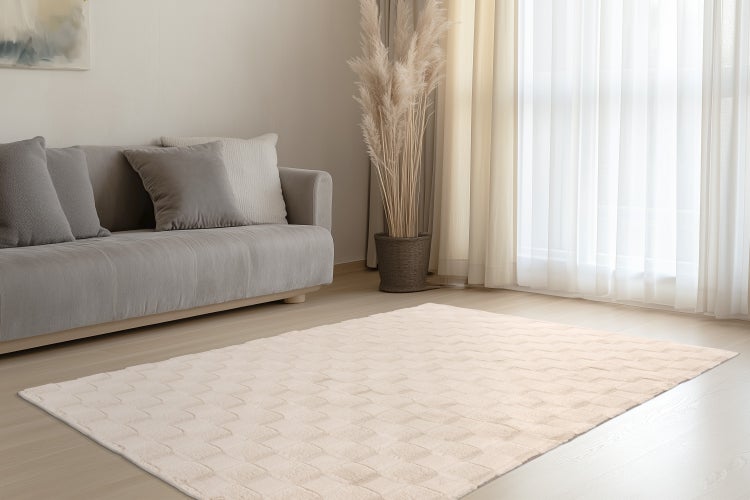 Nahaufnahme einer flauschigen Wohndecke aus Kunstfell mit gestepptem Muster.