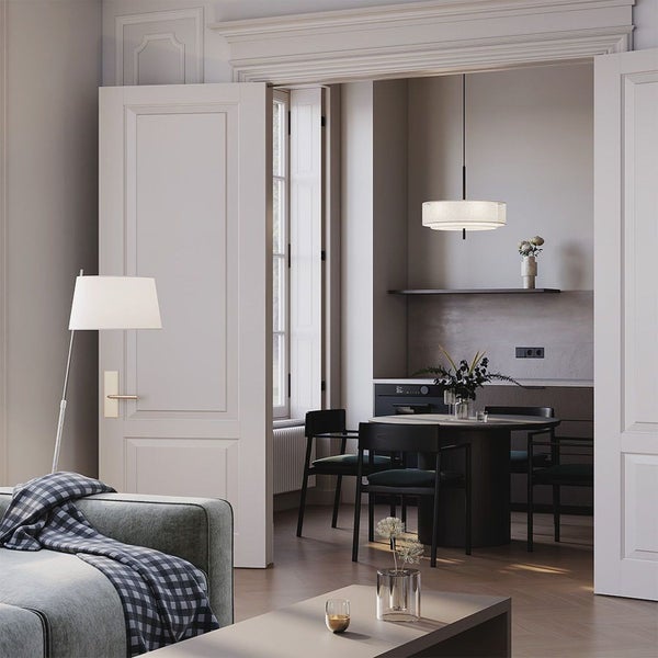 Wohnzimmer mit Sofa, Stehlampe, Tisch und Essbereich im Hintergrund