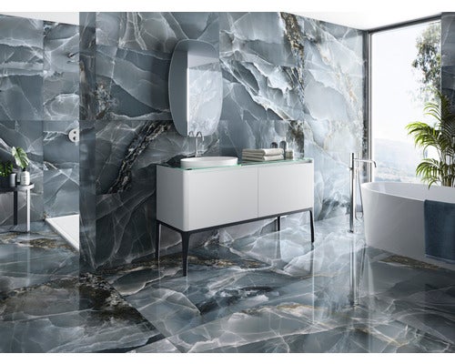 Helles Badezimmer mit Onyxfliesen an Wänden und Boden, Badewanne, Waschbecken und Spiegel