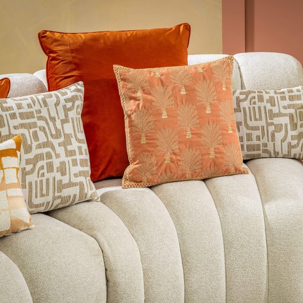 Dekorative Kissen in verschiedenen Größen und Mustern auf einem Sofa