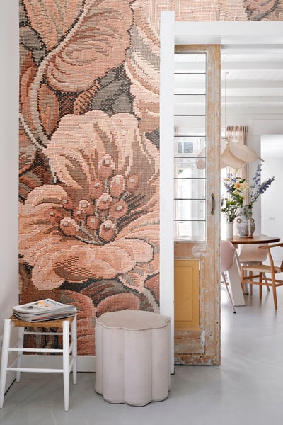 Dekorative Wandtapete mit Blumenmuster neben einem Hocker und einem restaurierten Fenster