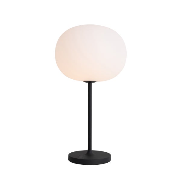 Moderne Tischleuchte mit rundem Glasschirm und schwarzem Standfuß.