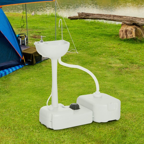 Mobiles Handwaschbecken aus Kunststoff mit Fußpumpe, Seifenspender und Abwassertank auf einer Wiese beim Camping.