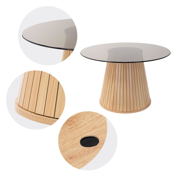 Modernes Wohnzimmer mit rundem Couchtisch mit Glasplatte und Holzlamellengestell, Sessel mit Decke und gemustertem Teppich.