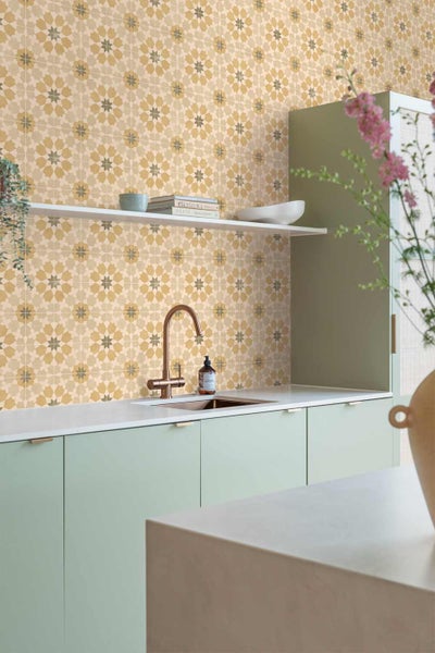 Moderne Küche mit gemusterten Wandfliesen im Stern-Design, hellgrünen Schränken, weißer Arbeitsplatte und einer Armatur aus Bronze.