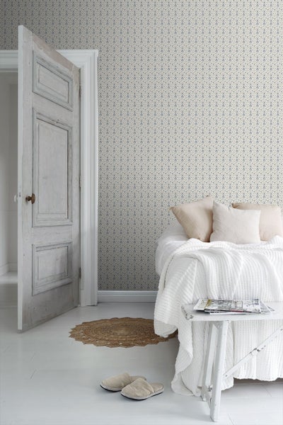 Schlafzimmer mit floral gemusterter Tapete, Bett und offenstehender Tür