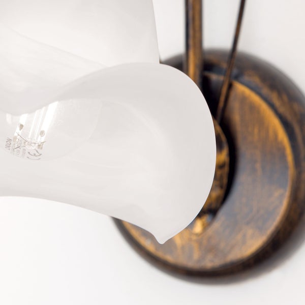 Wandleuchte mit blütenförmigem Glasschirm und metallischer Halterung im rustikalen Stil