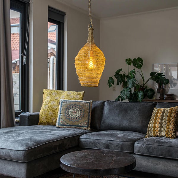 Hängelampe aus geflochtenem Material über einer Couch in einem Wohnzimmer.