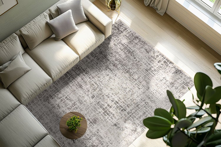 Wohnzimmer mit modernem Sofa, rundem Beistelltisch und einem rechteckigen Teppich mit abstraktem Muster auf hellem Holzboden.