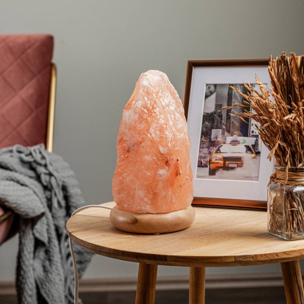 Detailansicht einer Lampenfassung mit Kabel an einem Holzsockel