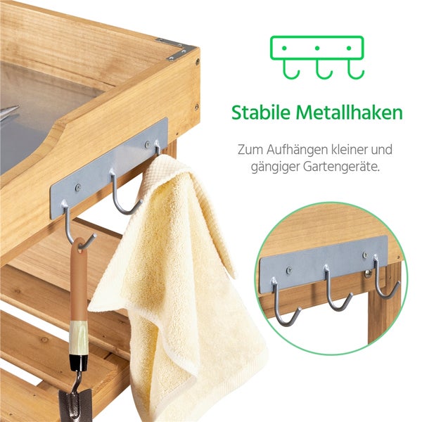 Detailansicht eines Gartentisches mit Metallhaken, an denen eine Gartenschaufel und ein Handtuch hängen.