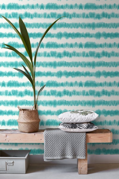 Szene mit einem Zimmer mit einer Wandtapete mit Streifenmuster, einer Bank, Kissen, einer Zimmerpflanze und einer Kiste.