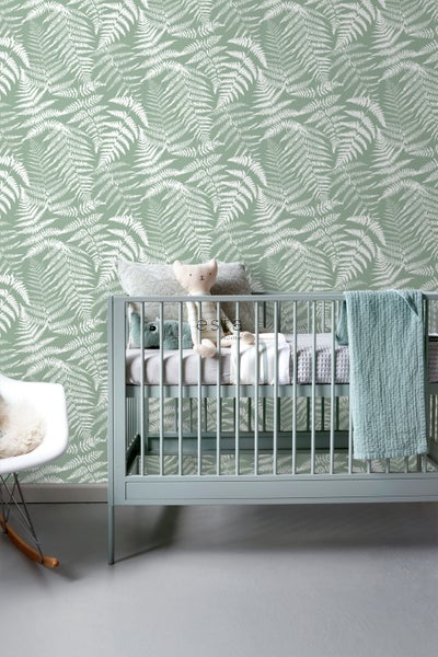 Babyzimmer mit Wandtapete mit Farnmotiv, Babybett und Schaukelstuhl