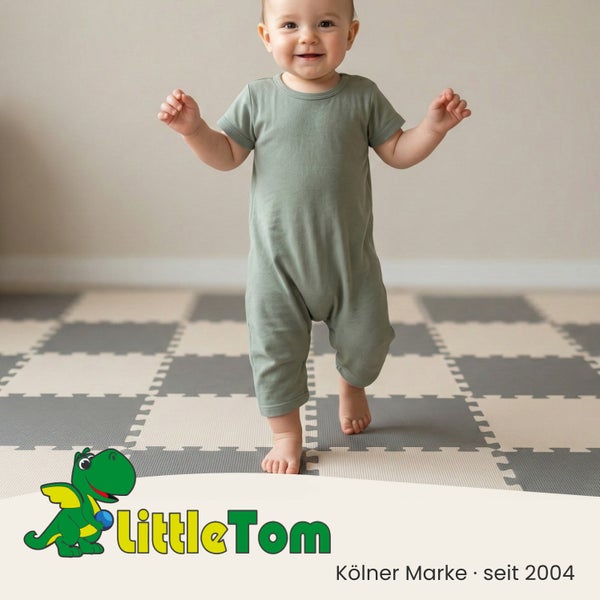 Kleinkind läuft auf einer schachbrettartigen Puzzlematte aus Schaumstoff in einem hellen Raum. LittleTom Logo.