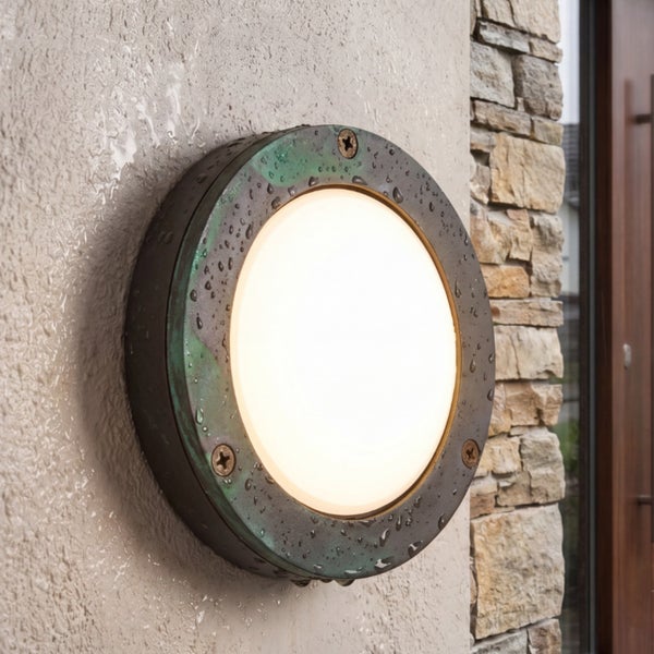 Runde Außenwandleuchte aus Metall mit mattem Glas an einer Hauswand.