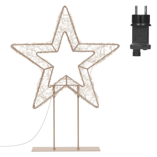 Wohnzimmer mit Sessel, Beistelltischen, Zimmerpflanzen und Landschaftsbild an der Wand unter einer geometrischen Pendelleuchte.