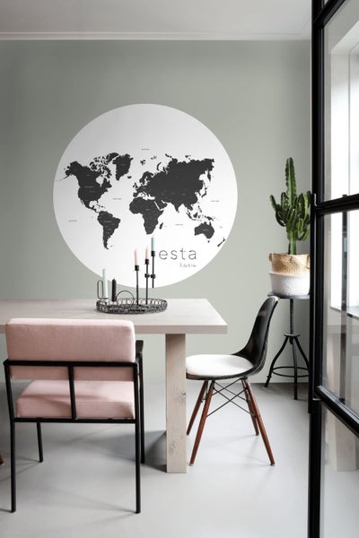 Helles Esszimmer mit Esstisch, Stühlen, Weltkarte und Zimmerpflanze