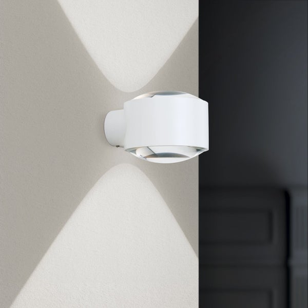 Moderne weiße Wandleuchte mit Up-and-Down-Lichteffekt, zylindrisches Design mit Glaslinsen, wirft Lichtkegel an die Wand.