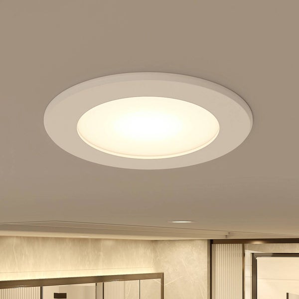 Runde LED-Einbauleuchte an der Decke, eingeschaltet mit warmem Licht in modernem Ambiente.