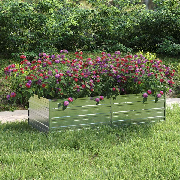 Rechteckiges Hochbeet aus verzinktem Wellblech im Garten, bepflanzt mit bunten Blumen.