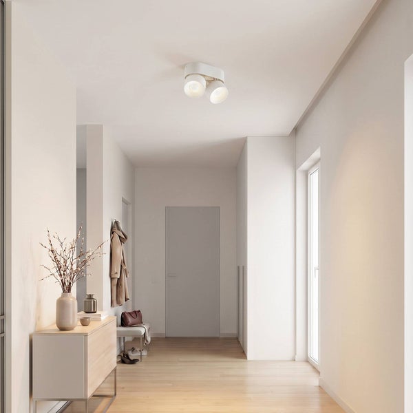 Moderne Deckenleuchte mit zwei Spots im hellen Flur mit Holzkommode und Garderobe.