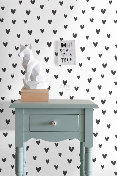 Dekoratives Zimmer mit Nachttisch, Fuchsskulptur und Herzmuster-Tapete.