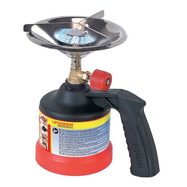 Bauarbeiter mit Schutzhelm liest Zeitung auf der Baustelle neben einem Gaskocher