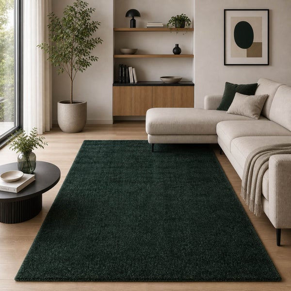 Dunkelgrüner Hochflor-Teppich in einem hellen, modernen Wohnzimmer mit hellem Sofa, Holzregalen und einer großen Zimmerpflanze.