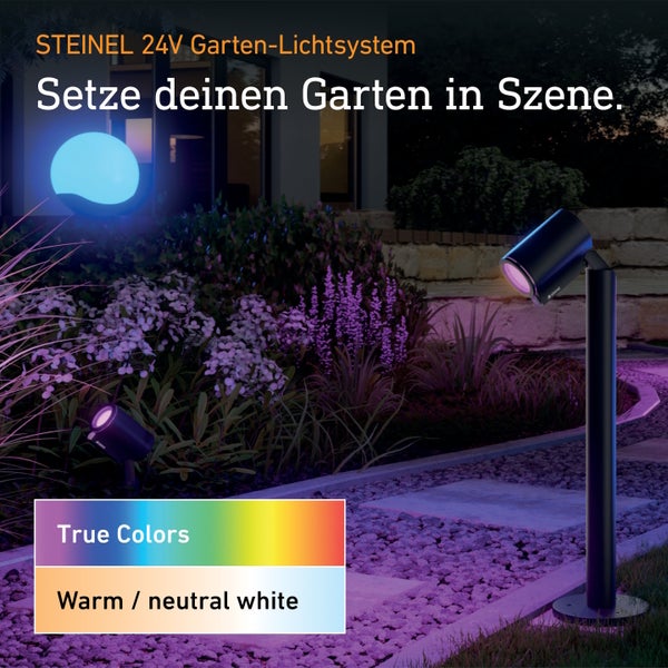 Steinel 24V Garten-Lichtsystem mit Wegeleuchte und Strahlern im beleuchteten Garten bei Nacht.
