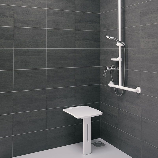 Barrierefreier Duschbereich mit weißem Klappsitz, Haltegriff mit Brausestange und Handbrause vor dunkelgrauen Fliesen.