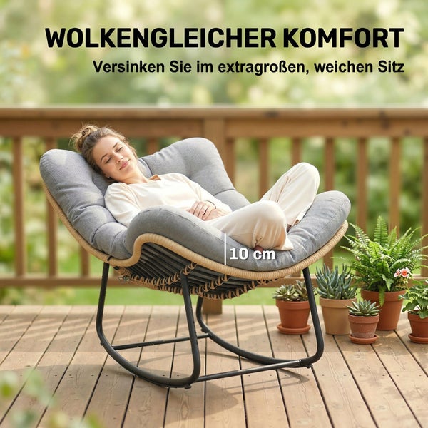 Eine Person entspannt in einem großen Schaukelstuhl mit grauem, 10 Zentimeter dickem Polster auf einer Holzterrasse.