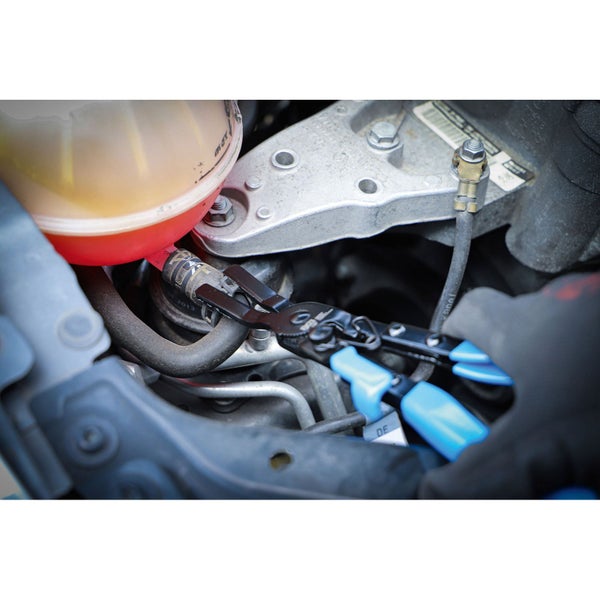 Eine Schlauchklemme wird mit einer Rohrzange an einem Motor befestigt.