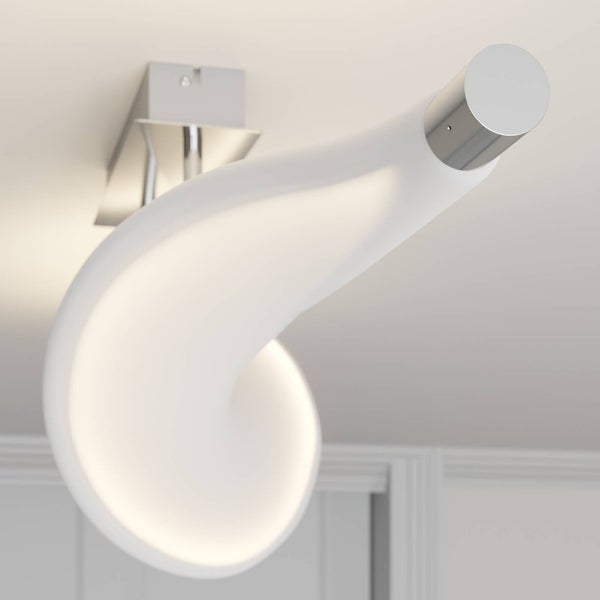 Moderne, geschwungene LED-Deckenleuchte aus Metall und Kunststoff an einer Zimmerdecke.